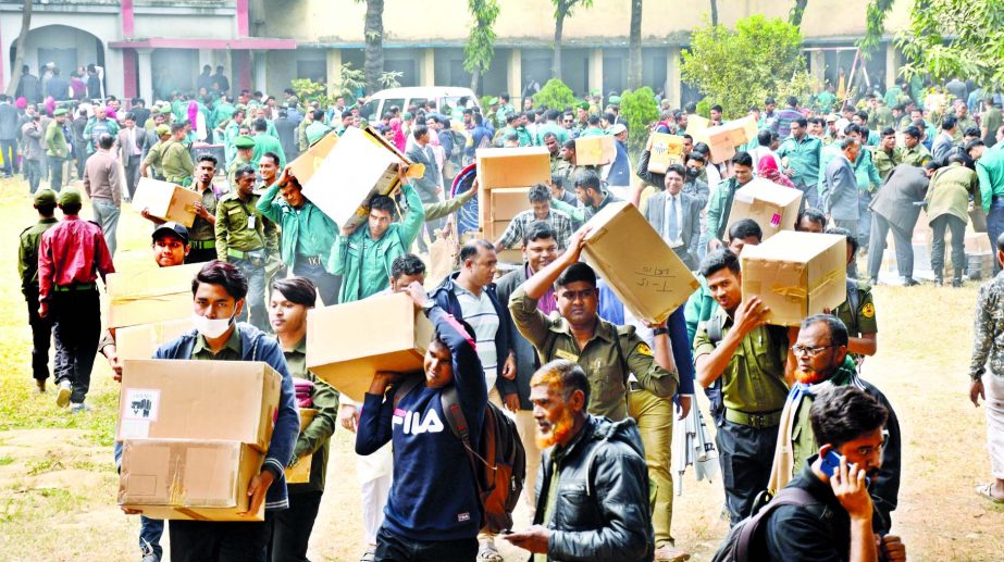 Election officials and security personnel carry voting material including Electronic Voting Machines (EVMs) on the eve of the Dhaka north and south city corporations on Friday. This photo was taken from Motijheel TNT Colony.