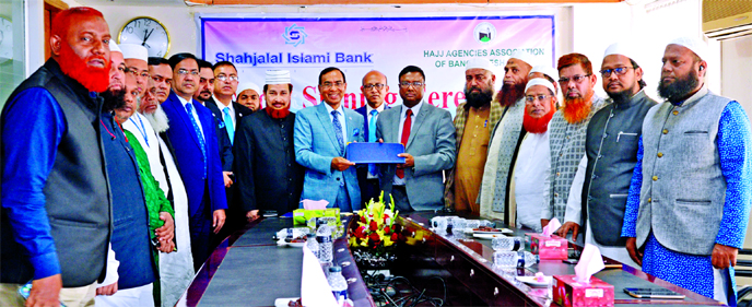 M. Shahidul Islam, Managing Director of Shahjalal Islami Bank Limited and M Shahadat Hossain Taslim, President of Hajj Agencies Association of Bangladesh (HAAB), exchanging document after signing a MoU at a hotel in the city on Monday. Under the deal, al