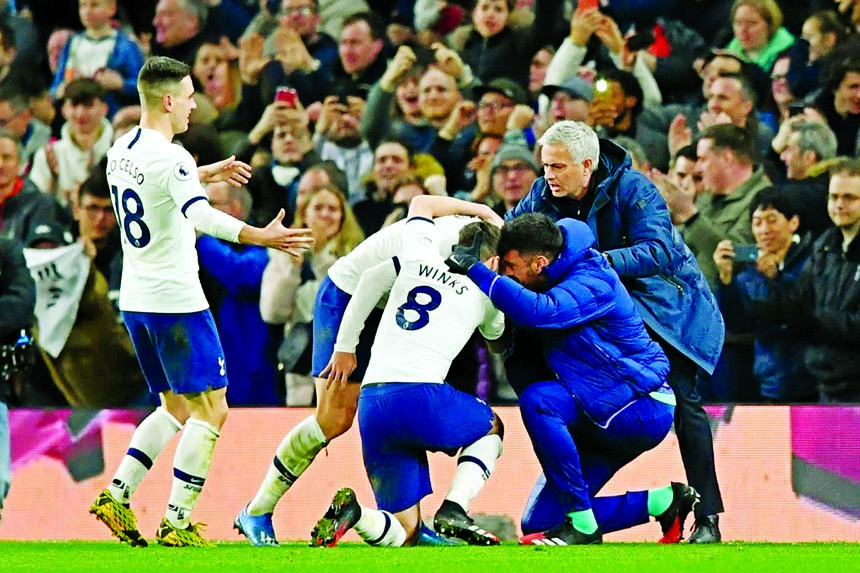 Tottenham Hotspur's South Korean striker Son Heung-Min celebrates with teammates and their head coach Jose Mourinho (right) after scoring their second goal during the English Premier League match between Tottenham Hotspur and Manchester City at Tottenham