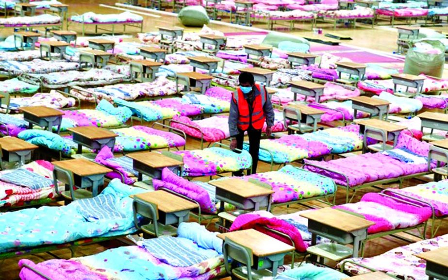 A worker sets up beds at the Hongshan Stadium to convert it into a makeshift hospital following an outbreak of the new coronavirus, in Wuhan, Hubei province on Tuesday.