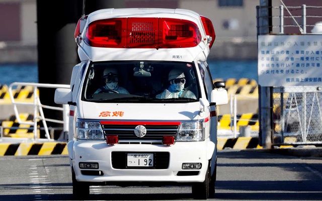 Ambulance workers in protective gear drive an ambulance which is believed to carry a person who was transferred from cruise ship Diamond Princess after ten people tested positive for coronavirus, at a maritime police's base in Yokohama, south of Tokyo, J