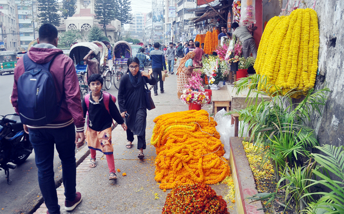 Pedestrians facing problem of movement as road-side flower business going on by occupying footpaths at Charag Point in the Port City . This snap was taken yesterday.