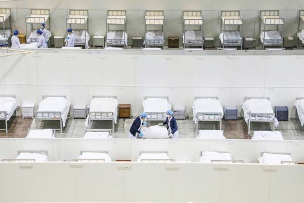 Medical staff set up beds for patients displaying mild symptoms of the coronavirus at an exhibition centre converted into a hospital in Wuhan in China