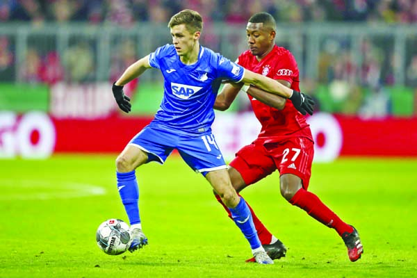 Bayern's David Alaba (right) challenges for the ball with Hoffenheim's Christoph Baumgartner during the German soccer cup, DFB Pokal, match between FC Bayern Munich and TSG Hoffenheim at Munich in Germany on Wednesday.