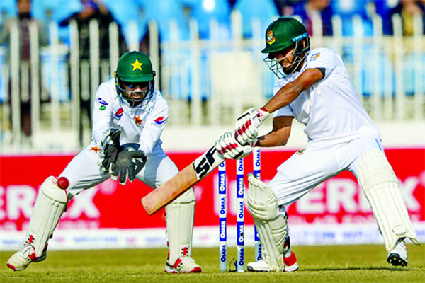 Bangladesh's Mohammad Mithun plays a shot as Pakistan's wicketkeeper Mohammad Rizwan looks on during the first day of the first Test match between Bangladesh and Pakistan at the Rawalpindi Cricket Stadium in Rawalpindi on Friday.