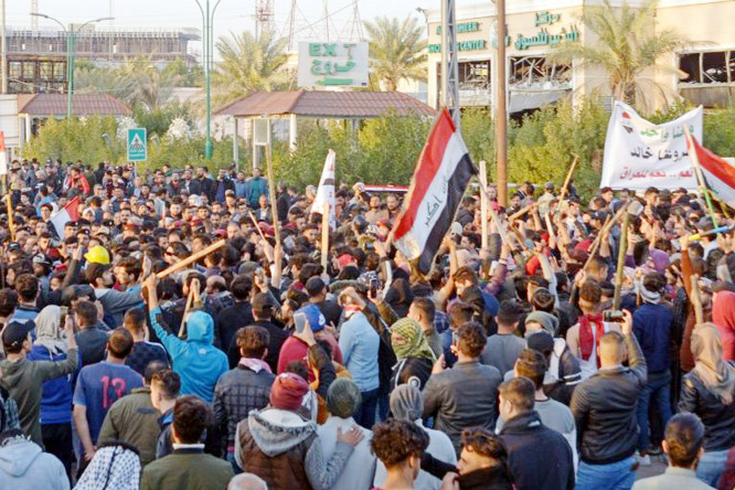 Iraqi followers of influential cleric Moqtada Sadr, carrying batons, clashed on Wednesday with anti-government protesters in the central holy city of Najaf.