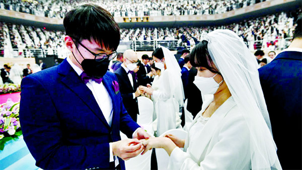 A couple wearing masks for protection from the new coronavirus, attends a mass wedding ceremony of the Unification Church at Cheongshim Peace World Center in Gapyeong, South Korea.