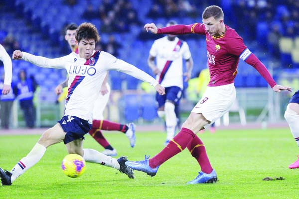 Roma's Edin Dzeko (right) and Bologna's Takehiro Tomiyasu vie for the ball during the Italian Serie A soccer match between Roma and Bologna at Rome's Olympic stadium on Friday.