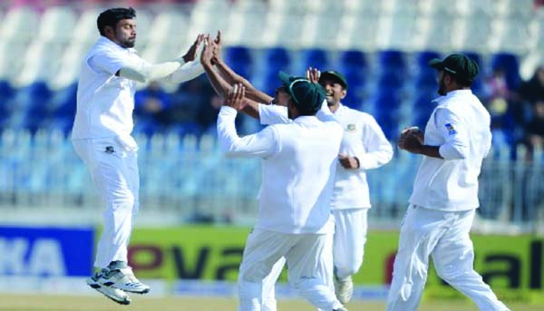 Bangladesh's Abu Jayed (left) celebrates with teammates after taking the wicket of Pakistan's Abid Ali (not in the picture) during the second day of the first Test cricket match between Bangladesh and Pakistan at Rawalpindi Cricket Stadium in Rawalpindi