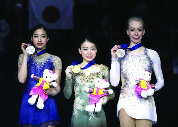 Gold medalist Japan's Rika Kihira (center) Silver medalist South Korea's You Young (left) and bronze medalist United States' Bradie Tennell (right) pose with their medals during the medal ceremony for the ladies' single free skating competition in the