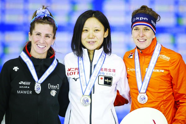 Japan's Miho Takagi (center) celebrates her victory with second-place finisher Canada's Ivanie Blondin (left) and third-place finisher Ireen Wust of the Netherlands following the women's 500-meter competition at the ISU World Cup speedskati