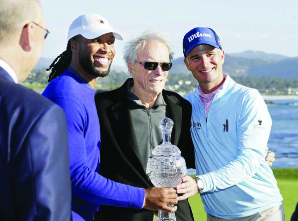 Larry Fitzgerald (left) and Kevin Streelman (right) pose with their trophy with Clint Eastwood (center) at the Pebble Beach Golf Links after winning the team title of the AT&T Pebble Beach National Pro-Am golf tournament in Pebble Beach of California o