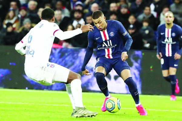 PSG's Kylian Mbappe tries to drive the ball past Lyon's Marcelo (left) during the League One soccer match between Paris Saint Germain and Lyon at the Parc des Princes stadium in Paris on Sunday.