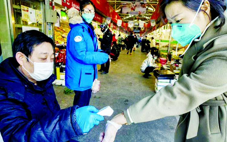 A woman is checked for fever before entering a market in Beijing.