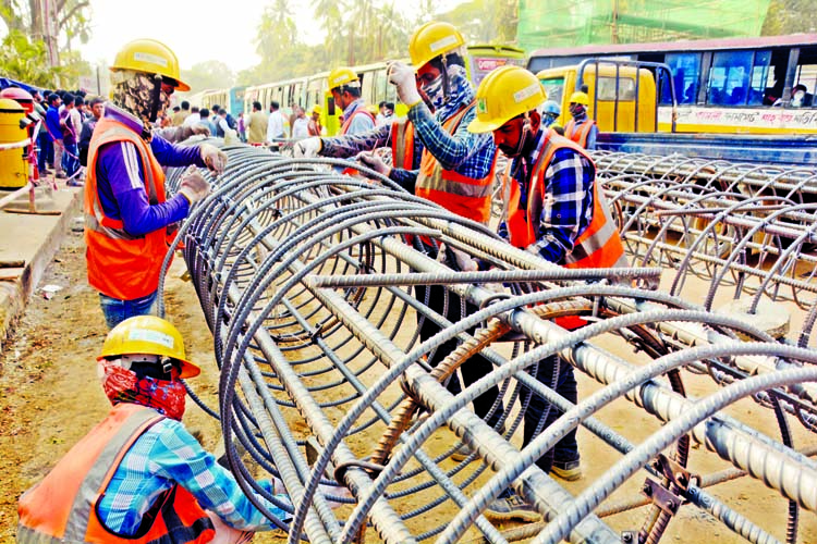 Works on the country's first ever metro rail project is going on in full swing with the hope to open for traffic by December next year. The photo taken on Monday shows construction workers preparing heavy steel framework for a portion of the project at T