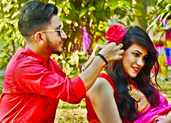 A fiance ties rose flower in the chignon of his fiancÃ©e in the city's Suhrawardy Udyan on Friday on the occasion of Valentine's Day.