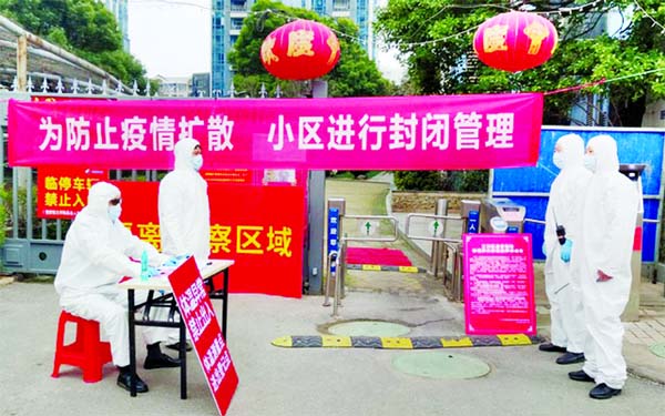 Workers in protective suits are seen at a checkpoint for registration and body temperature measurement, at an entrance to a residential compound in Wuhan, the epicentre of the novel coronavirus outbreak, in Hubei province, China.