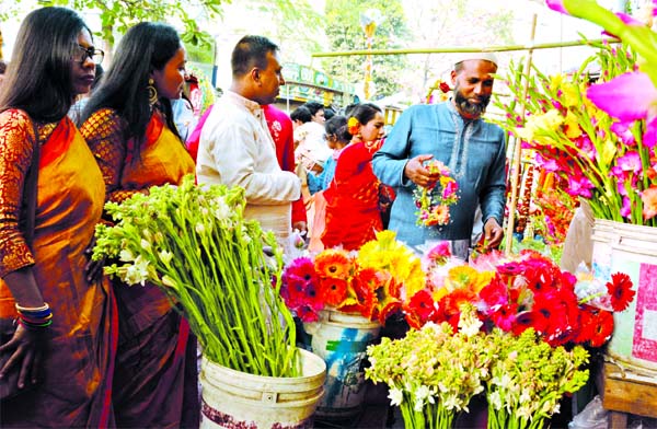 People are seen buying flowers for their beloved ones from a shop at the city's Shahbagh area on the occasion of Pahela Falgun and Valentine's Day on Friday.