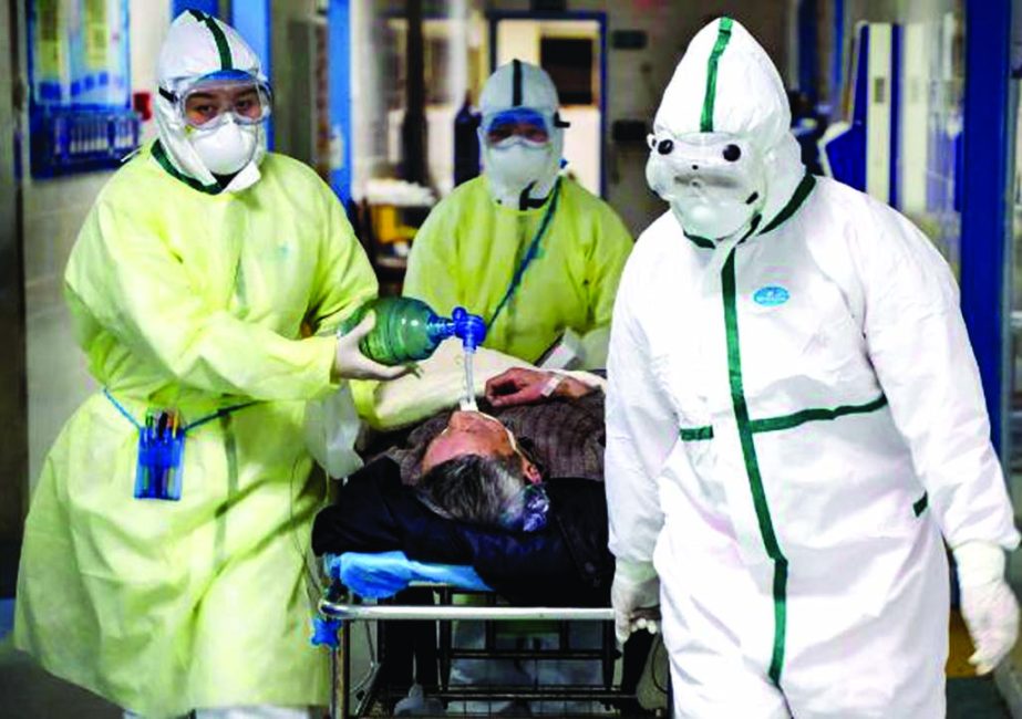 Medical workers in protective suits move a patient at an isolated ward of a hospital in Wuhan. Internet photo