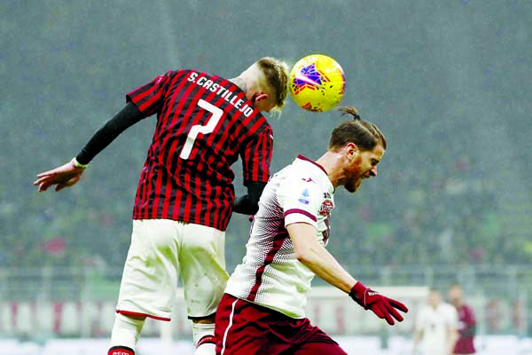 AC Milan's Samu Castillejo (left) jumps for the ball with Torino's Cristian Ansaldi during the Serie A soccer match between AC Milan and Torino at the San Siro stadium in Milan of Italy on Monday.