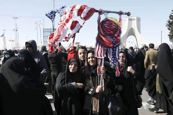 Demonstrators hold a caricature of President Donald Trump with a tattered U.S. flag in front of Azadi (Freedom) monument tower during a rally celebrating the 41st anniversary of the Islamic Revolution, at Azadi (Freedom) Street, in Tehran, Iran, on Tuesda