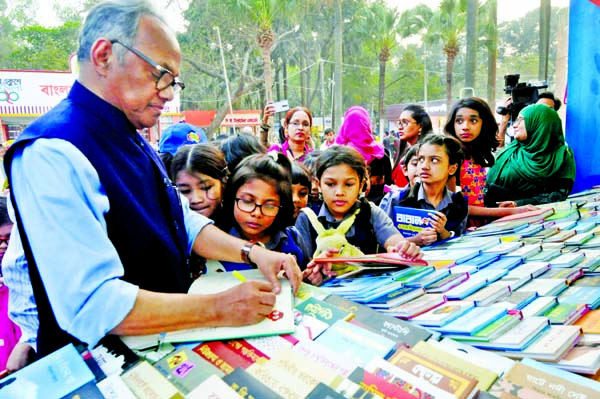 Eminent writer Emdadul Haque Milon giving autograph to children at the Ekushey Book Fair in the city's Suhrawardy Udyan on Tuesday.