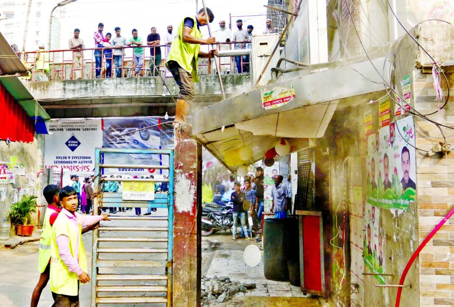 Workers of Dhaka North City Corporation (DNCC) knock an illegal establishment down at DNCC Gulshan market in a drive on Tuesday.