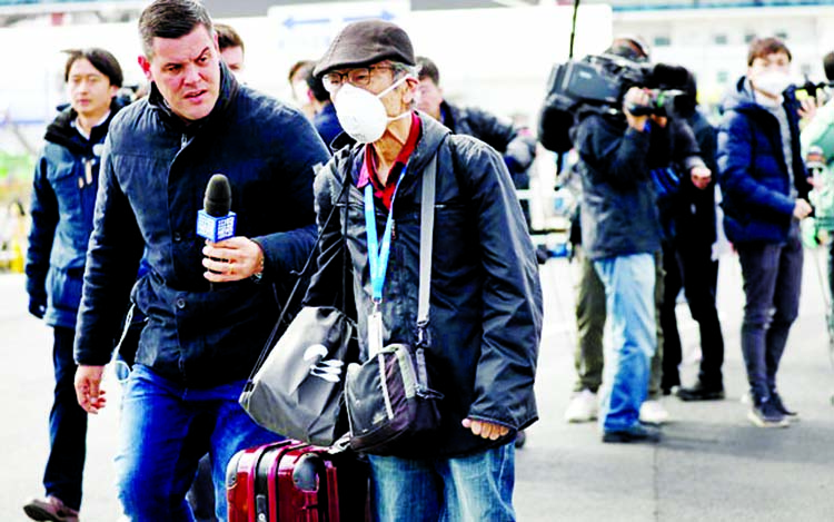 A member of the media approaches a passenger after he walked out from the cruise ship Diamond Princess at Daikoku Pier Cruise Terminal in Yokohama, south of Tokyo, Japan.