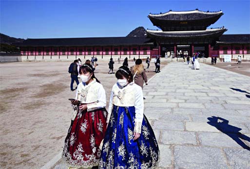 People in traditional Korean hanbok dresses wear face masks as they visit Gyeongbokgung palace in Seoul, on Sunday. Internet photo