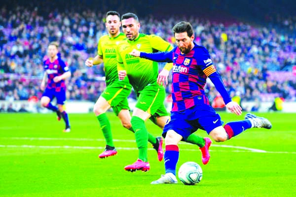 Barcelona's Argentine forward Lionel Messi (right) kicks the ball during the Spanish League football match between FC Barcelona and SD Eibar at the Camp Nou stadium in Barcelona on Saturday.