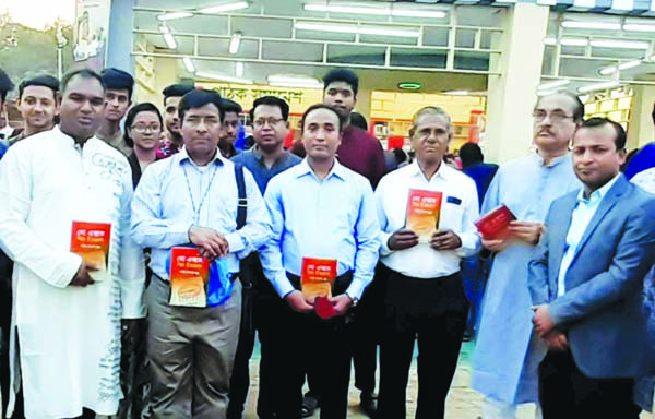 Principal of Saint Gregory High School and College Brother Prodip Placid Gomes along with others holds the copies of a novel titled ' No Exam' at its cover unwrapping ceremony in front of Bishwa Sahitya Prokashoni Pavilion in Amar Ekushey Book Fair in t