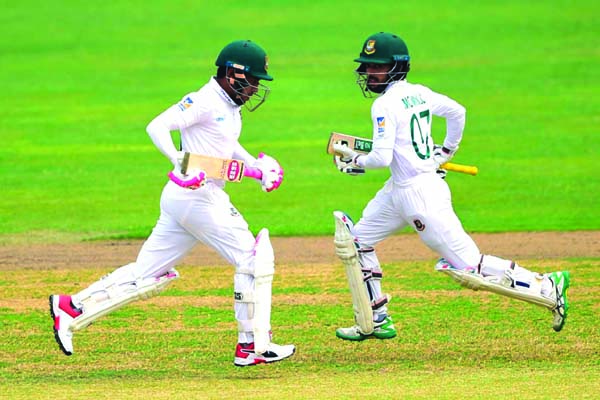 Mushfiqur Rahim (left) and Mominul Haque running between wickets during the third day play of the lone Test match between Bangladesh Cricket team and Zimbabwe Cricket team at the Sher-e-Bangla National Cricket Stadium in the city's Mirpur on Monday.