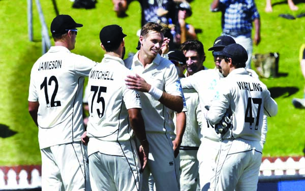 New Zealand's Tim Southee (center) is congratulated by teamates after taking the final wicket of India's Jasprit Bumrah during the first cricket Test between India and New Zealand at the Basin Reserve in Wellington of New Zealand on Monday.