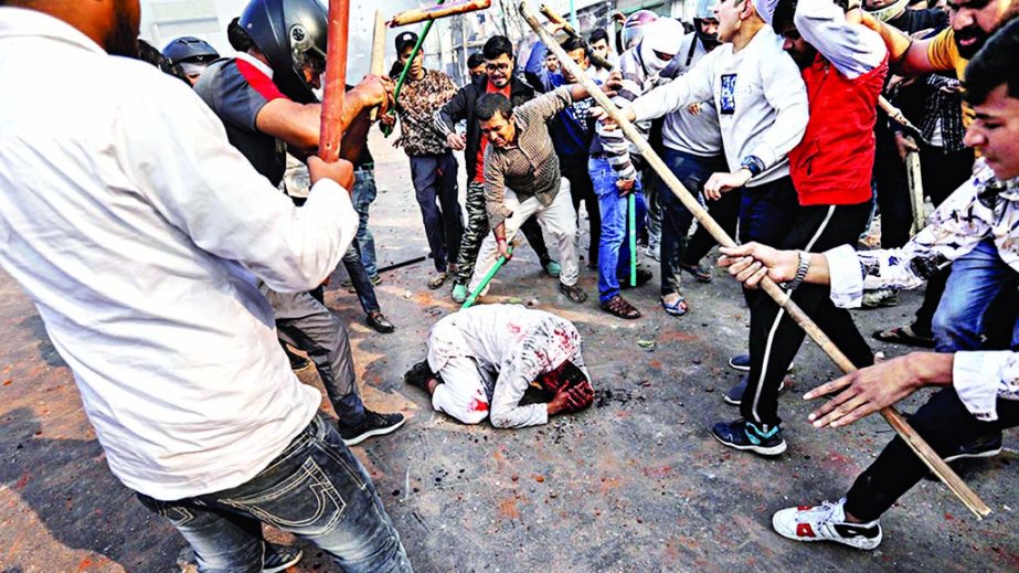 People supporting the new citizenship law beat a man during a clash with those opposing the law in New Delhi. Internet photo
