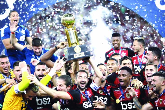 Players of Brazil's Flamengo celebrate with the trophy after defeating Ecuador's Independiente del Valle 3-0 in the final match of the Recopa at the Maracana stadium in Rio de Janeiro of Brazil on Wednesday.