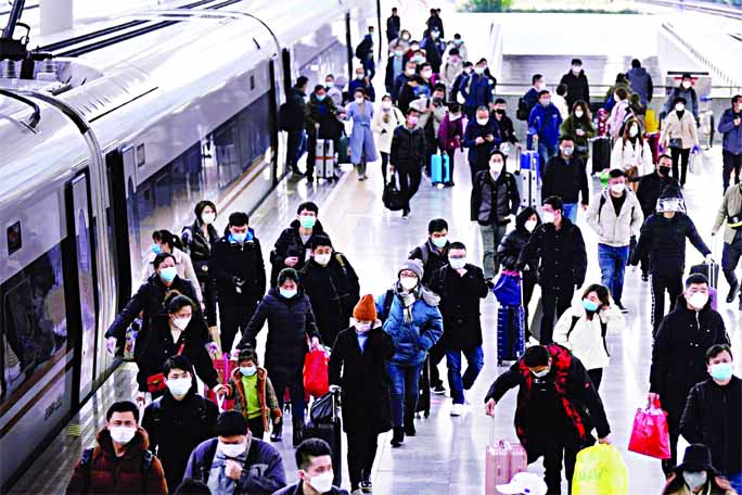 Passengers wearing masks are seen arrival at the Shanghai railway station in Shanghai, China, as the country is hit by an outbreak of a new coronavirus.