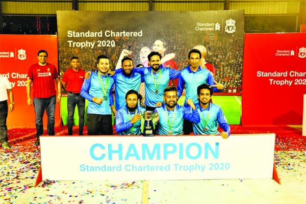 Players of Bangla Trac Limited, the champions in the Standard Chartered Football Tournament with Chief Executive Officer of Standard Chartered Bangladesh Naser Ezaz Bijoy and Captain of Bangladesh National Football team Jamal Bhuiyan pose for a photo sess