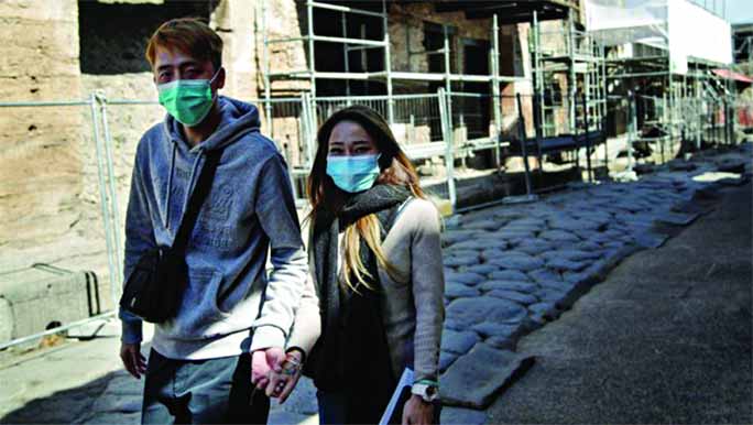 Tourists wearing masks are seen walking around the ruins of the ancient Roman city of Pompeii, Italy on Saturday.