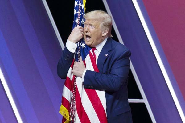 President Donald Trump kisses the American flag after speaking at Conservative Political Action Conference, CPAC 2020, at the National Harbor, in Oxon Hill, Md., on Saturday