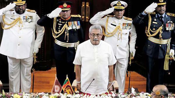Sri Lanka's President Gotabaya Rajapaksa stands for national anthem during the swearing in ceremony of his brother and former leader Mahinda Rajapaksa, who was appointed as the new Prime Minister, in Colombo.