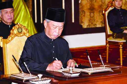 Malaysia's incoming prime minister Muhyiddin Yassin signing documents after taking the oath as the country's new leader at the National Palace in Kuala Lumpur. Internet photo