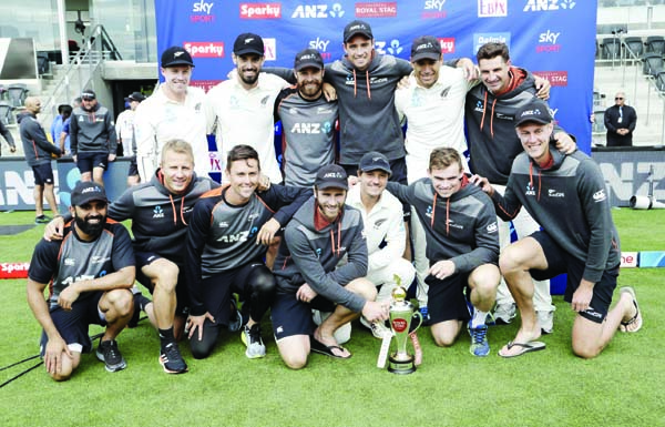 The New Zealand team pose with their trophy after wining the series against India 2-0 following play on day three of the second cricket Test between New Zealand and India at Hagley Oval in Christchurch of New Zealand on Monday.