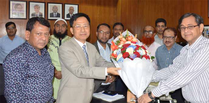 Chief Information Commissioner Martuza Ahmed greeting Sudatto Chakma, newly appointed Information Commission Secretary, by handing over flower.