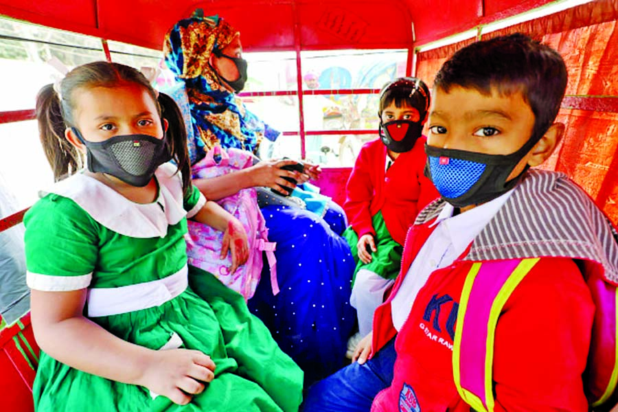 Children wearing masks are being taken to a school for protection against coronavirus.