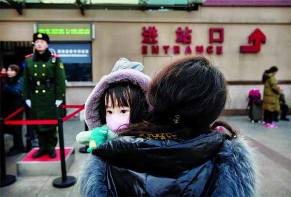 In Beijing's central railway station, a baby was found wearing a mask on mother's lap on Sunday.