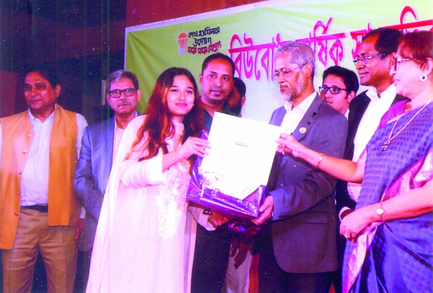 Chief guest Chairman of Bangladesh Power Development Board (BPDB) Engineer Md Belayet Hossain handing over the prize to a winner at the Mukti Hall in BPDB office of Dhaka on Sunday. The Sports and Cultural Council of BPDB arranged the prize-giving ceremon