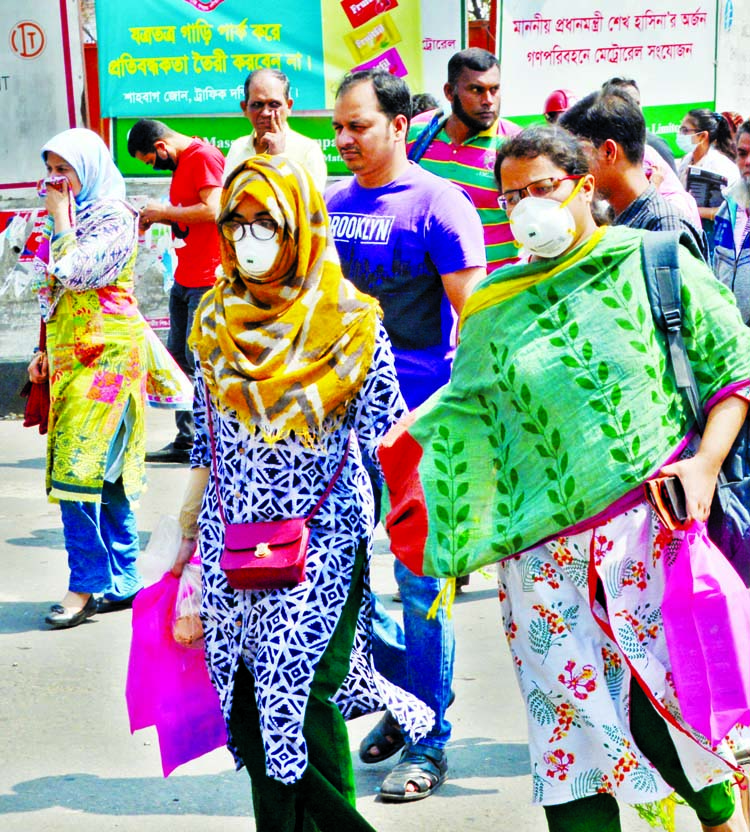 Pedestrians wearing face masks crossing Shahbagh intersection on Monday as a preventative measure following coronavirus outbreak.