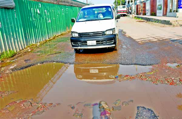 The road infront of Bangladesh Public Service Commission at Agargaon in Dhaka has become dilapidated and water remains stagnant for days turning it terrible for the movement of vehicles. This photo was taken on Monday.