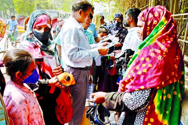 Pedestrians buy protective masks from a footpath vendor at Hatirpool in Dhaka on Monday.