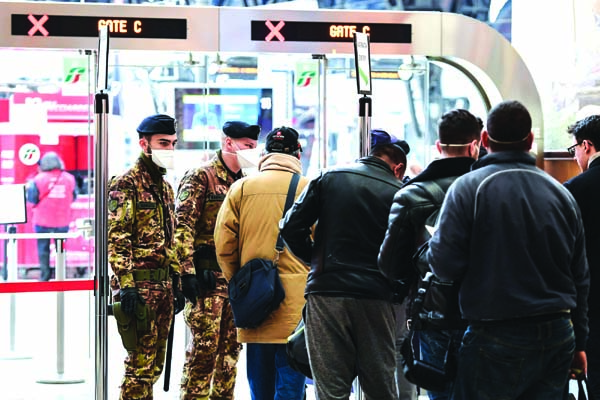 Soldiers check passengers accessing platforms to board trains at the Milan Central Railway station